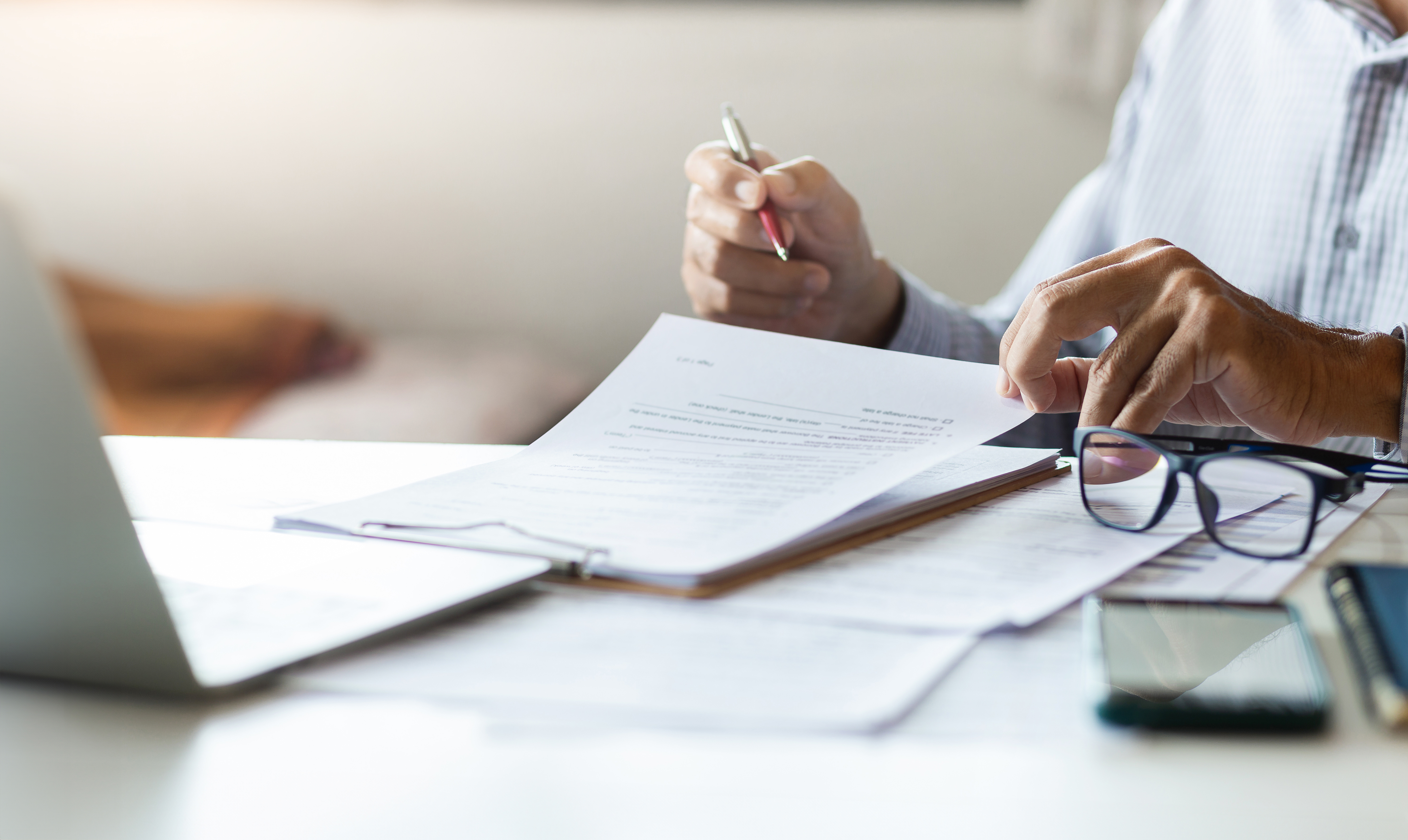 Professional reviewing a legal form beside a laptop