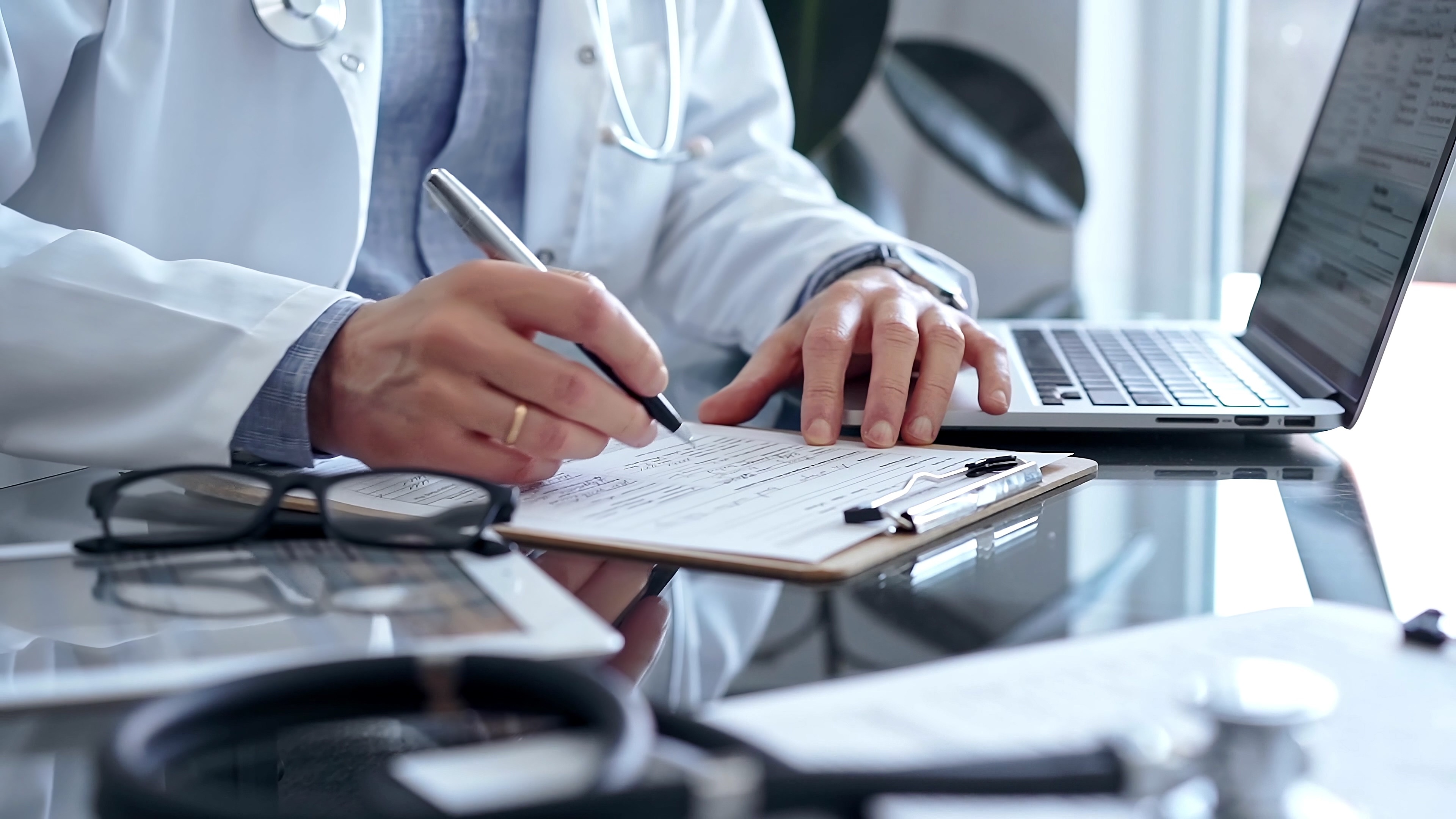 Physician completing medical evaluation form with clinical documentation