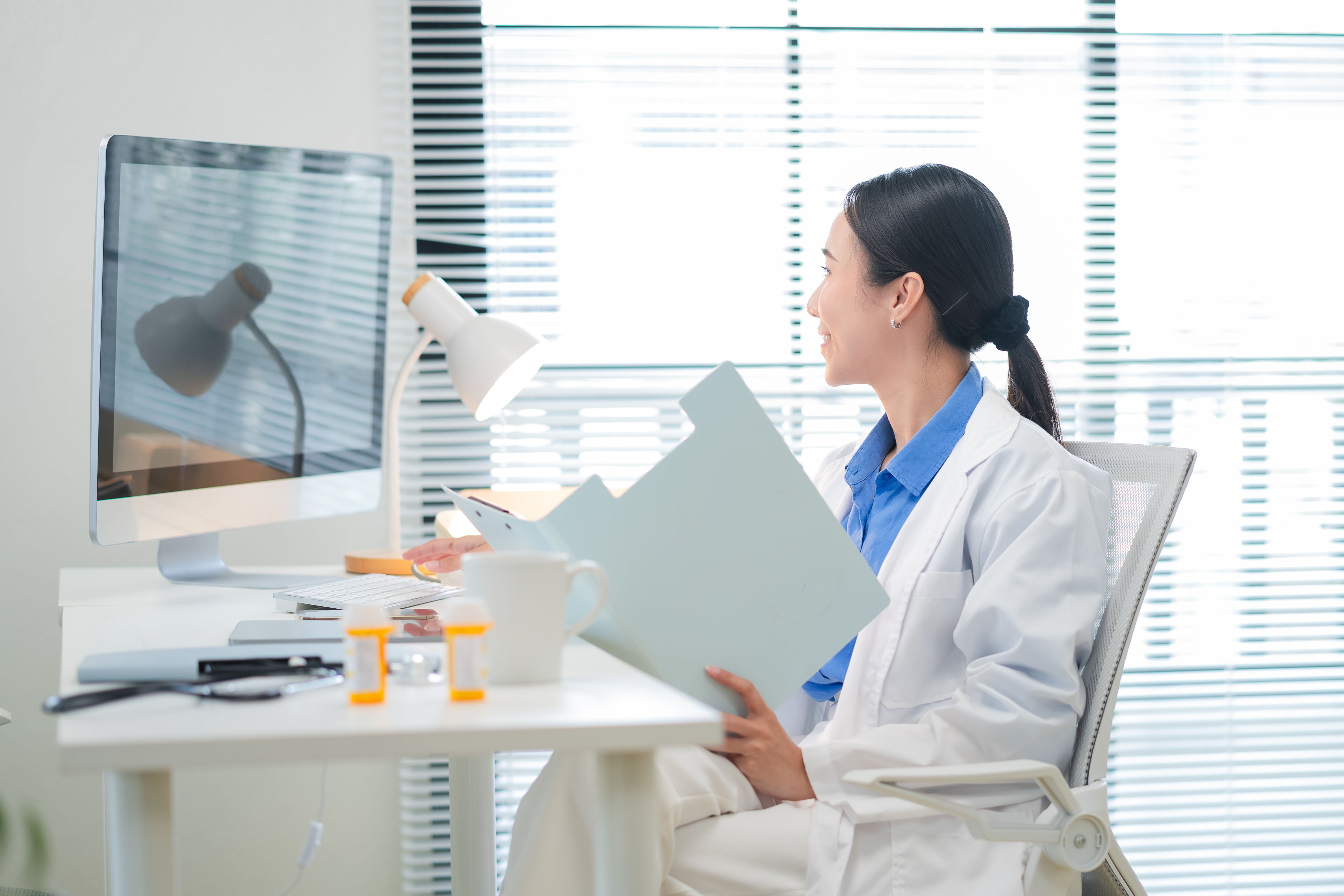 Physician reviewing spinal imaging and medical records at a workstation